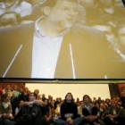 Un grupo de jóvenes siguen el mitin de Mariano Rajoy en Pamplona a través de una gran pantalla