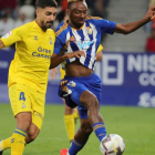 Kelechi disputa una pelota a Álex Suárez en el Deportiva-Las Palmas. L. DE LA MATA