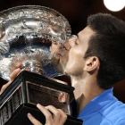Novak Djokovic besa el trofeo que le acredita como campón del Abierto de Australia.
