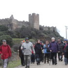 Caminantes por la ruta de invierno a Santiago dejando a sus espaldas el Castillo de Cornatel.