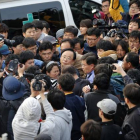 El ministro surcoreano Lee Ju-young, en el centro de la imagen, con gafas, es increpado por familiares de los pasajeros del 'Sewol'.