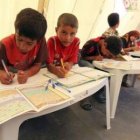 Niños libios que huyeron de la violencia van a clase en un campo de refugiados.