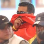 Un paramilitar se tapa el rostro para no ser reconocido en el acto de entrega de indultados