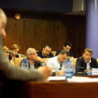 En primer plano, Santiago Macías, con la bancada del PP al fondo y Riesco observándole.