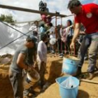 Voluntarios del campo de trabajo se afanaban ayer en desenterrar los restos en la fosa de Cabañinas