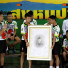 Los niños rescatados en Tailandia posan junto a un retrato del buzo fallecido. PONGMANAT TASIRI
