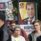 Peatones pasas por delante de un cartel electoral en San Petersburgo.
