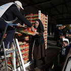 Juani Pérez, la directora, reparte los lotes a los voluntarios para que los entreguen a las personas que llegan pidiendo alimentos.