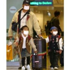 Una familia surcoreana se protege con mascarillas en el aeropuerto de Beijing