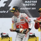 Jenson Button, regado con cava por Fernando Alonso, celebra su segundo triunfo en el Mundial de 2011