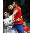 El jugador español Alberto Entrerríos se eleva sobre el defensa argelino para intentar un lanzamiento a portería.
