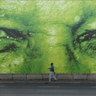 Un hombre pasa en frente de un gigante mural del histórico presidente sudafricano, Nelson Mandela.