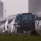 Trabajadores equipados con trajes especiales desinfectan la granja afectada ubicada en Holton