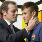 Rosell y Neymar posan ante el escudo del Barça en las oficinas del club el día de la presentación del jugador.