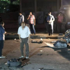 Oficiales de seguridad inspeccionan los restos de un coche bomba que estalló este martes en un distrito de Guiza, vecina de El Cairo.