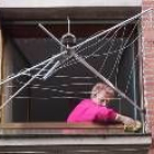 Una mujer limpia la ventana de su casa