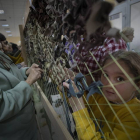 Una niña ucraniana ayuda a colocar una verja de camuflage para el ejército de UCrania. MARIA SENOVILLA