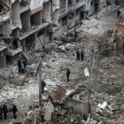 Vecinos inspeccionan los edificios en ruinas tras varios bombardeos el día anterior en Duma, feudo rebelde de Guta Oriental (Siria), el 22 de febrero.