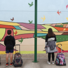 Alumnos de un colegio leonés ante un mural de una iniciativa educativa.