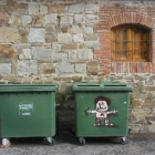En la foto, una imagen de dos contenedores en La Bañeza, uno de ellos con un curioso dibujo.