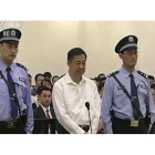 Bo Xilai (centro), flanqueado por dos policías, en el inicio del juicio contra él, este jueves.