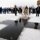 Un sacerdote cristiano ortodoxo se sumerge en agua helada durante la Epifanía en San Petersburgo, Rusia.