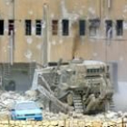 Una gran máquina israelí destruía ayer el muro que protege el edificio de la Autoridad Palestina