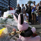 Varias personas colocan flores, velas y un peluche en tributo a las víctimas del atentado en Niza, este viernes.