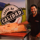 Pablo Aparicio posa con una pieza de carne en su carnicería en Veguellina de Órbigo. J. NOTARIO