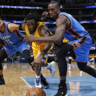 Andre Roberson y Serge Ibaka corren por el balón, en el choque entre los Thunder y los Nuggets en Denver.