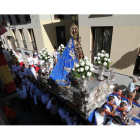 Una mujer arroja unos ramos de hierbabuena desde su balcón al paso de la imagen de la Virgen de la Encina