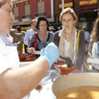 Unas mujeres reciben su ración de alubias después de hacer cola, ayer en La Bañeza.