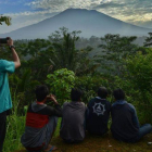 Un grupo de personas observa el volcán Agung en la isla de Bali.