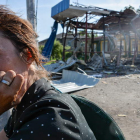 Una mujer delante de un edificio destruido por el Ejército.