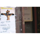 Un cartel con un crucifijo señalaba ayer el lugar donde Manuel Dos Anjos pedía limosna a las puertas de Caja España.