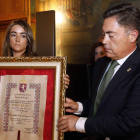 Loreto Rodríguez Carrasco, hija de Isabel Carrasco, recibe la acreditación de la Medalla de Oro de manos de Martínez Barazón.