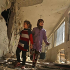 Dos niñas sirias recorren su escuela, destrozada el día anterior por los ataques áereos de la aviación gubernamental, en la sitiada ciudad de Saqba (Guta Oriental), el 9 de noviembre.