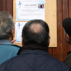 Vecinos de los fallecidos observan la esquela de los dos ancianos encontrados muertos. LUIS TEJIDO