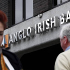 Dos viandantes pasan por delante de una agencia del Anglo Irish Bank, en Dublín, en septiembre del 2010.