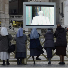 Un grupo de monjas observa en una pantalla gigante de San Pedro la marcha del Papa.