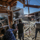 Los palestinos inspeccionan sus negocios tras la devastación del bombardero israelí. MOHAMMED SABER
