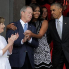 La primera dama, Michelle Obama, abraza al expresidente George Bush, en el momento de llegar con Obama a la inauguración del museo de África inaugurado en Washington.