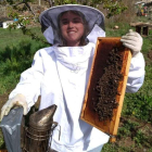 Belén Blanco posando junto a un panel con cientos de abejas. DL