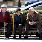 Tres jubilados charlan animadamente en un banco público. M.P.