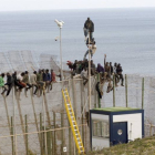 El grupo de inmigrantes de origen subsahariano que permanece encaramados en la parte alta de la valla de Melilla