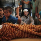 Un chico palestino contempla el cuerpo de la niña palestina Yasmeen al Motawaq.
