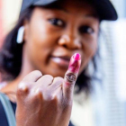 Una senegalesa muestra su dedo manchado con tinta endeleble, tras depositar su voto en las elecciones presidenciales del 24 de febrero del 2019.