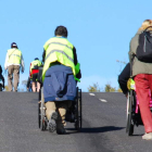 Un grupo de voluntarios ayuda a discapacitados en silla de ruedas.