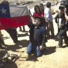 El minero Jorge Galleguillos toma una bandera de Chile marcada con su nombre.