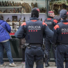 Varios Mossos patrullan la tarde de este martes por la Fira de Santa Llúcia, en la plaza de la Catedral.